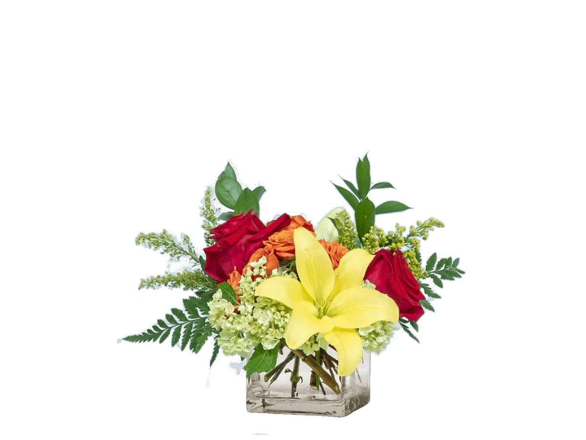 Bouquet of red roses, yellow lilies, and orange flowers in a clear square vase