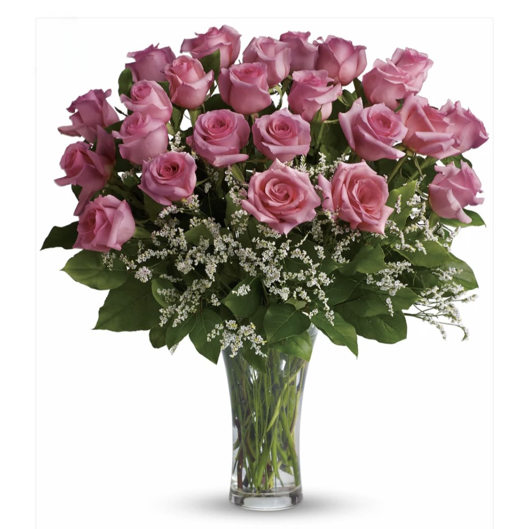 Pink roses arranged in a clear glass vase with white filler flowers