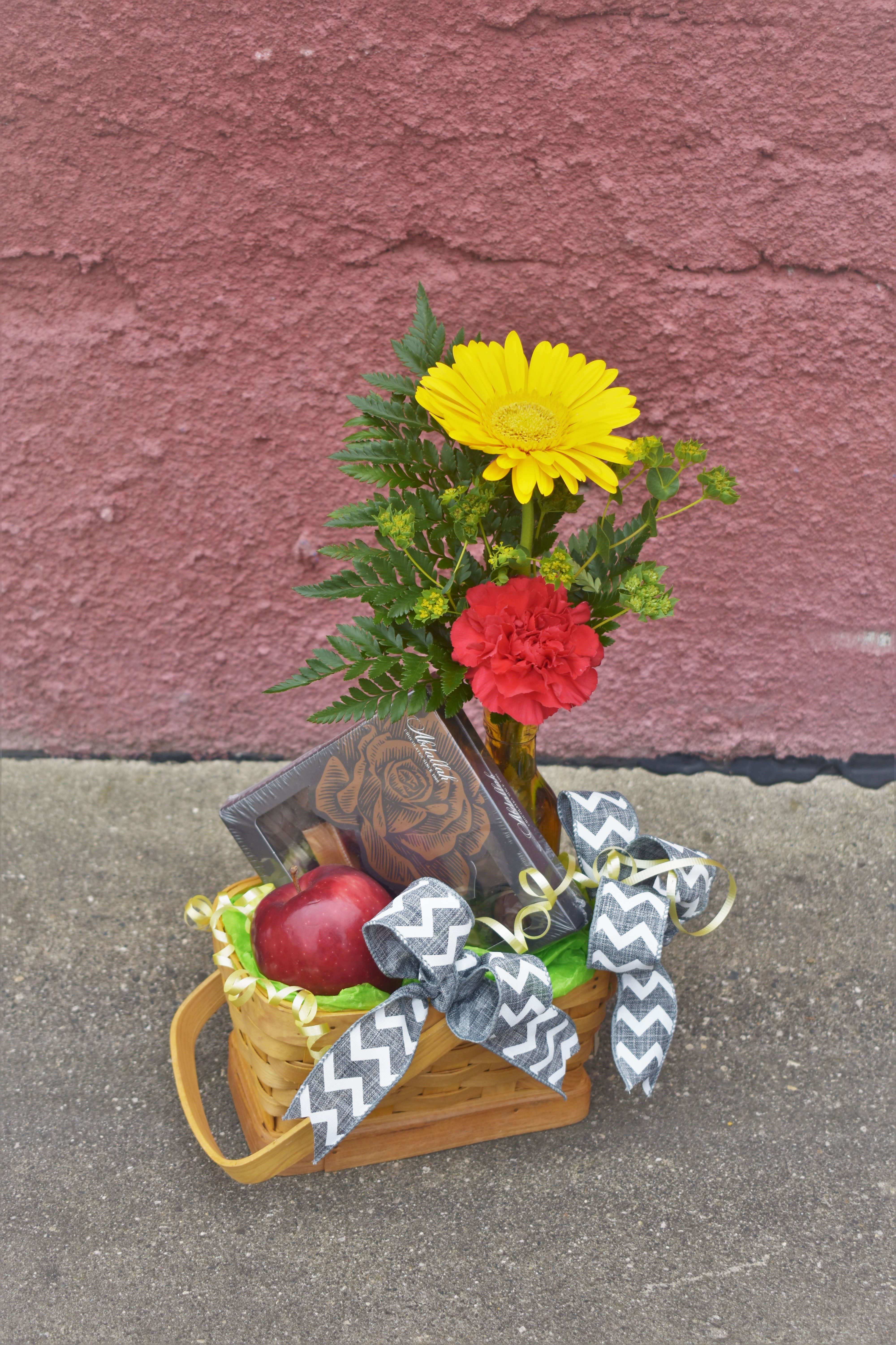 Teacher's Pet - *Please note, the basket pictured is out-of-stock. We can make the same design in a different-colored/styled basket. Thank you for your understanding!  The perfect gift for the 1st day of school! A basket designed with a flower bouquet, Made in MN gourmet chocolates, and a fresh, crisp apple is a great way to start off the school year! Great as a gift for teachers or students. We also customize gift baskets, so call us at 320-587-3110 and we will design your specific requests!  