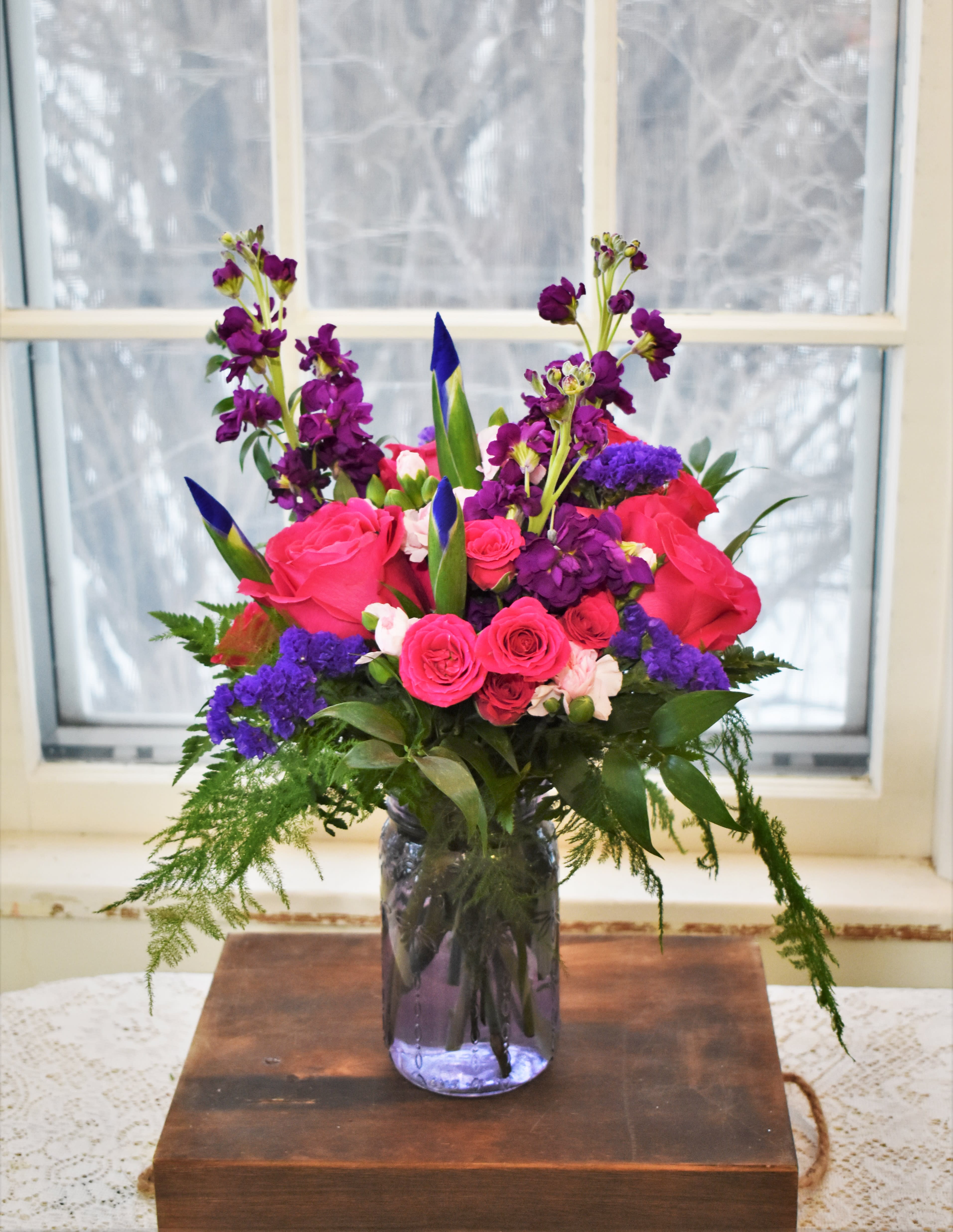 Pink and purple floral arrangement in a glass vase