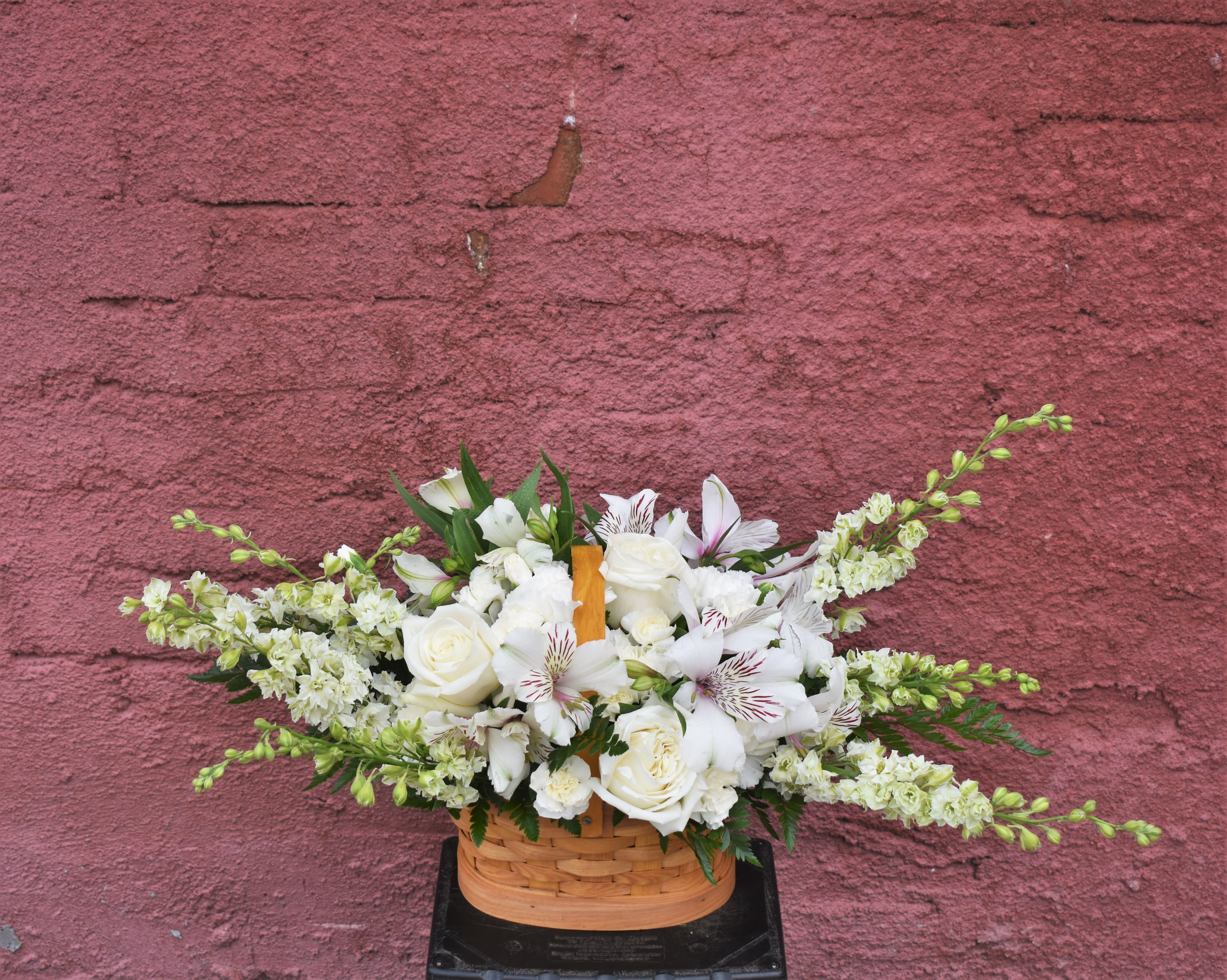 Peaceful Garden Basket - Peaceful Garden Basket offers warmth and comfort through its display of snow-white blooms. Roses, larkspur and Peruvian lilies are artfully arranged in a natural round woodchip basket, creating the perfect way to convey your wishes for peace and tranquility during this time of loss and sadness.