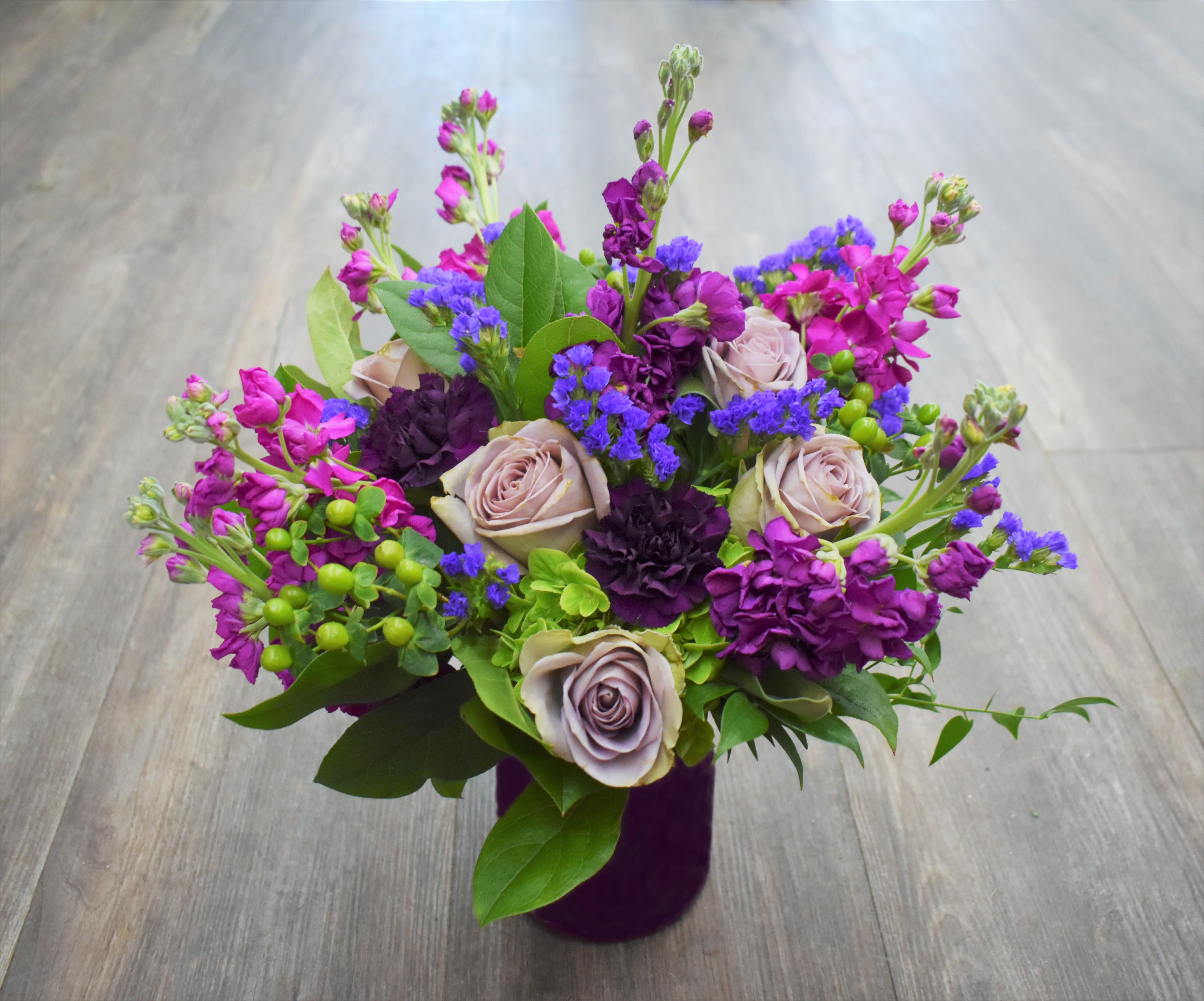 Purple and pink mixed bouquet in a dark vase