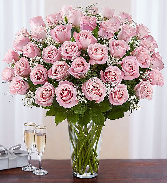 Pink roses arranged in a clear glass vase with baby’s breath