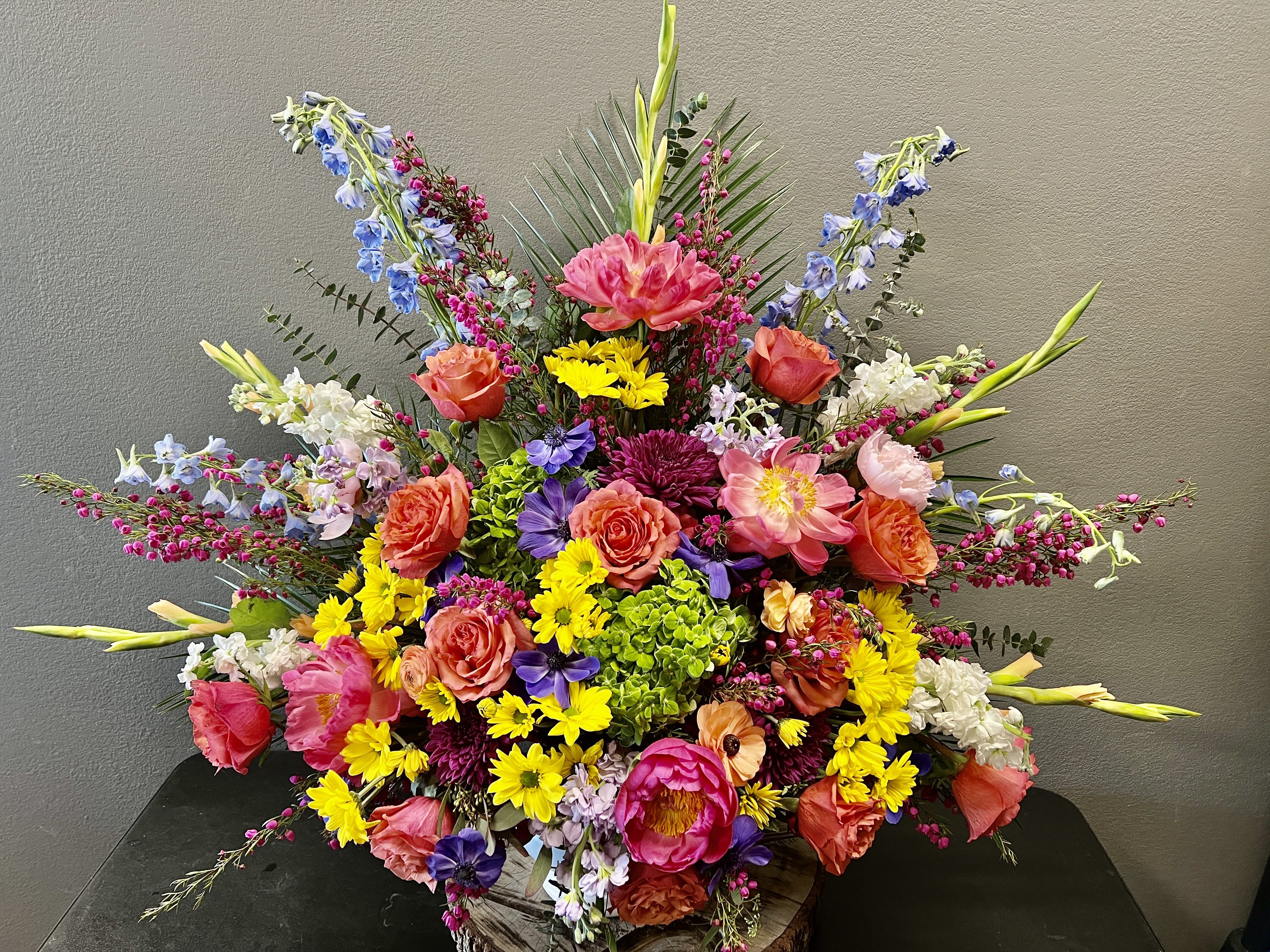 Large colorful floral arrangement with roses, lilies, and mixed blooms