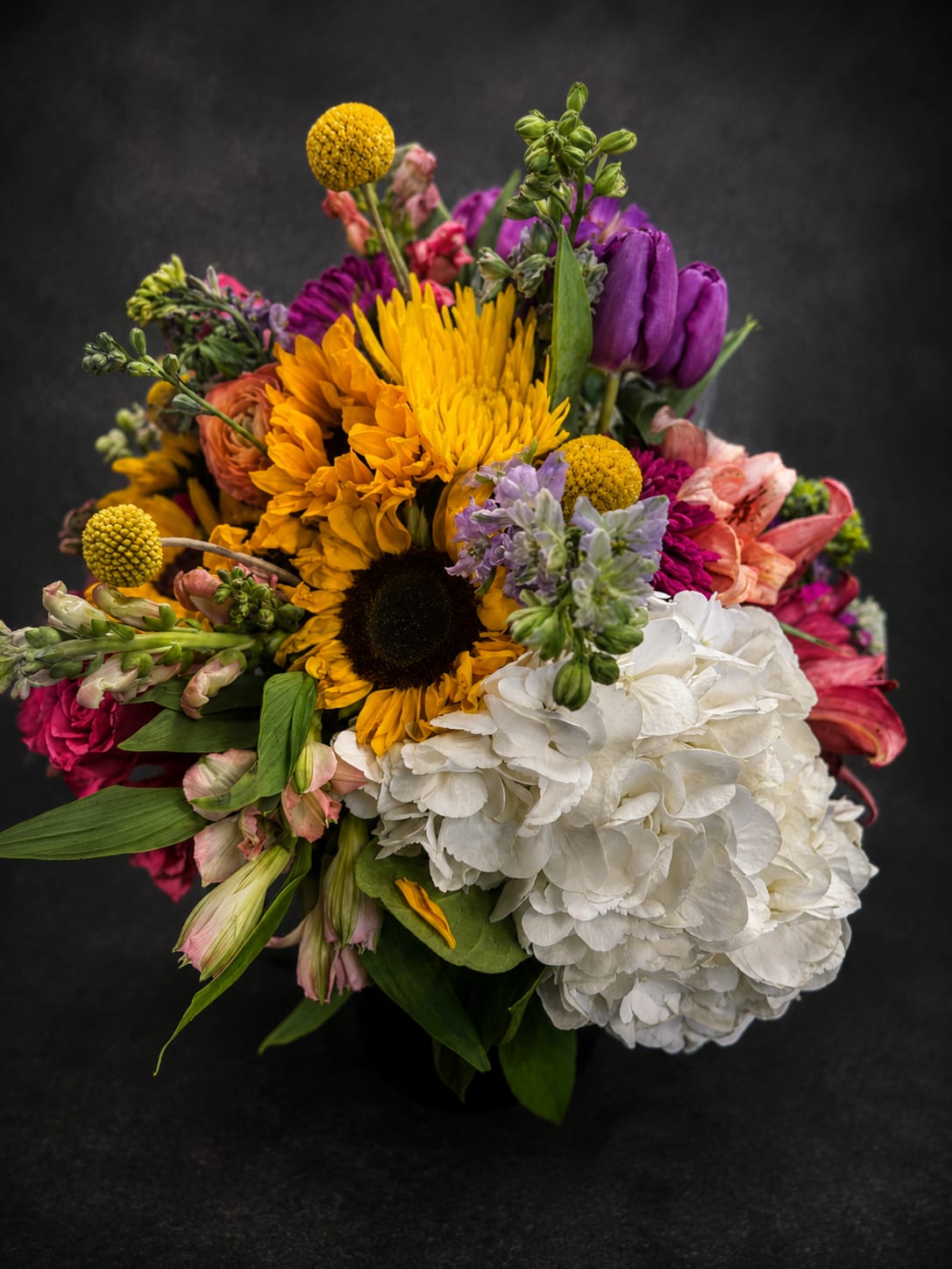Sunny Day - A lower arrangement using sunflowers and other bright flowers to make someone feel special. 