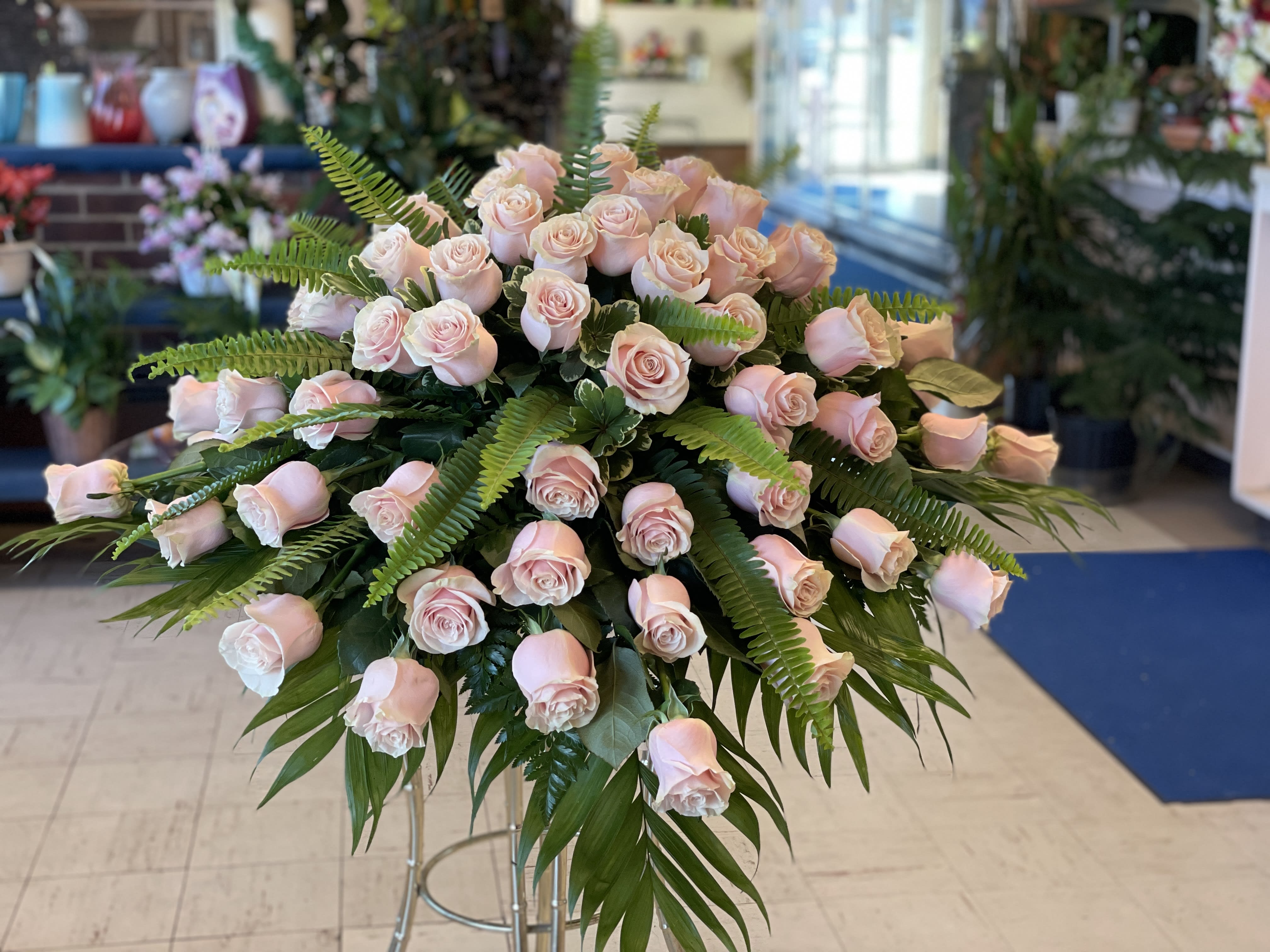 Large arrangement of pale pink roses with fern foliage