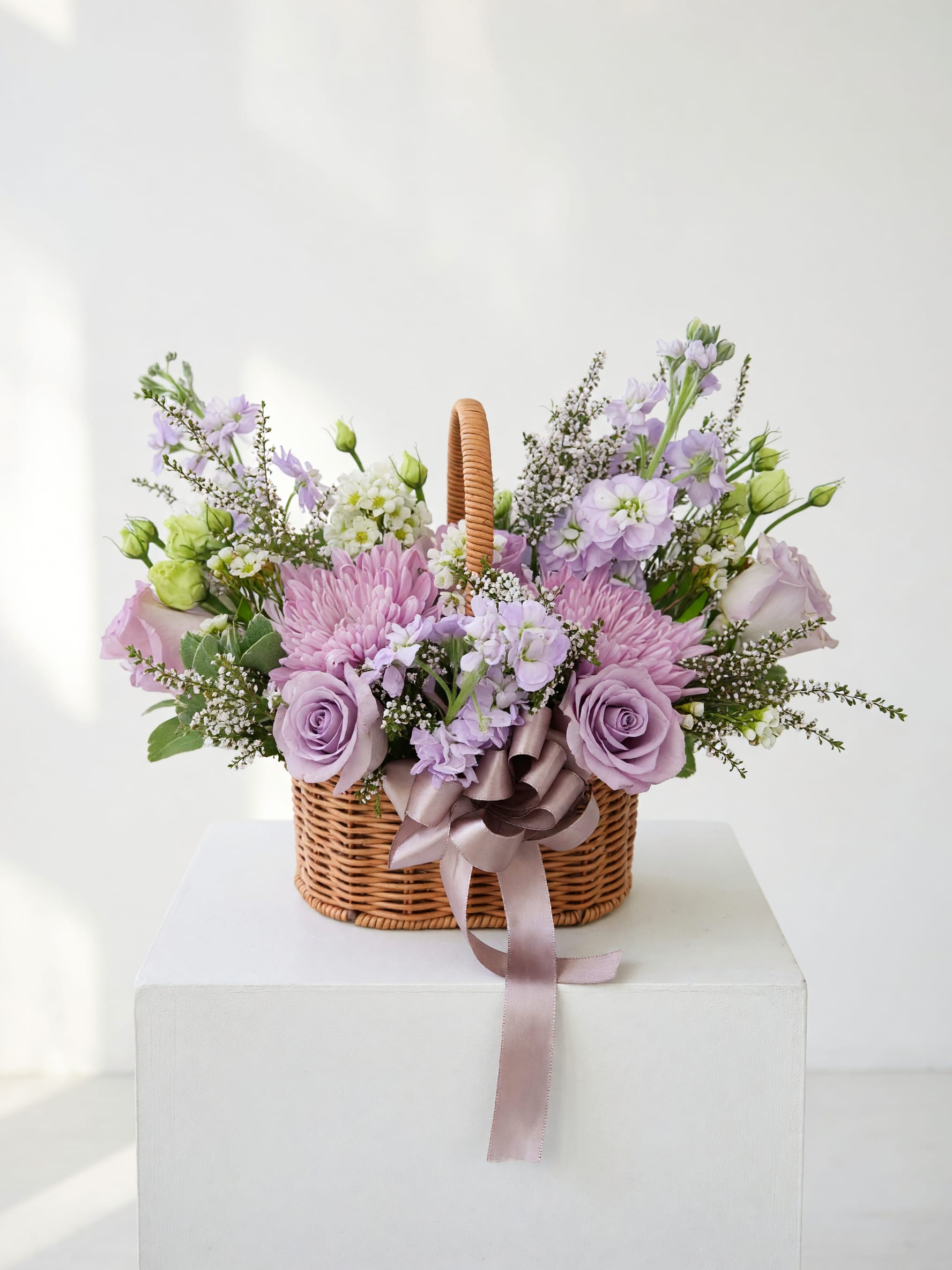 Lavender and pink flower basket with a ribbon bow