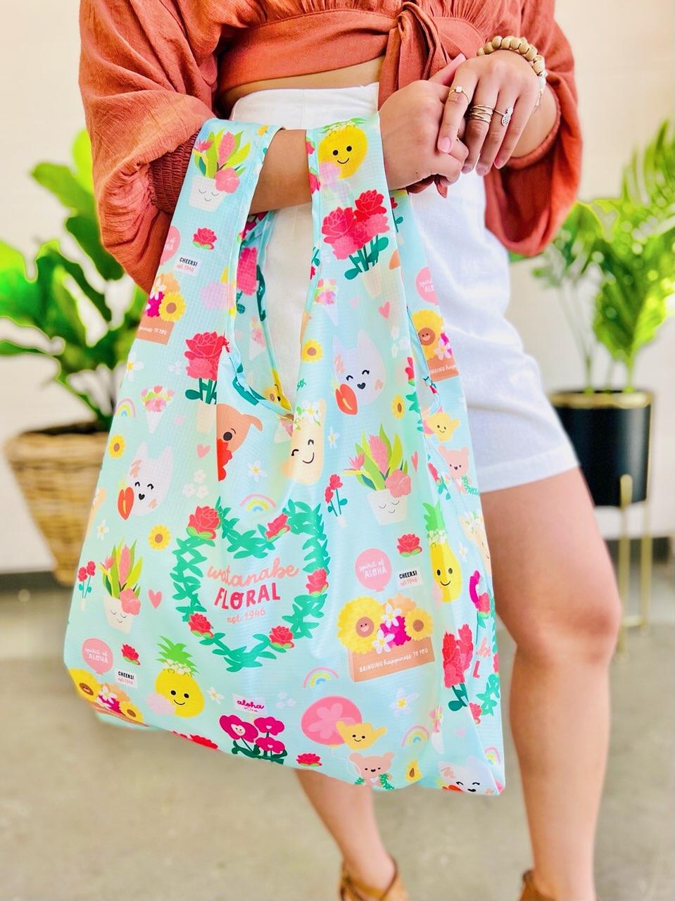 Reusable pastel tote bag with cute floral and character illustrations held by a person indoors