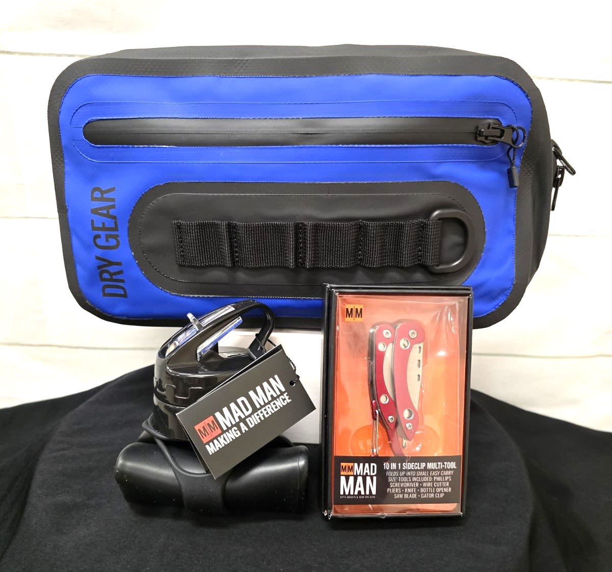 Outdoor gift set with blue dry gear bag, multi-tool, and black gadget with carabiner