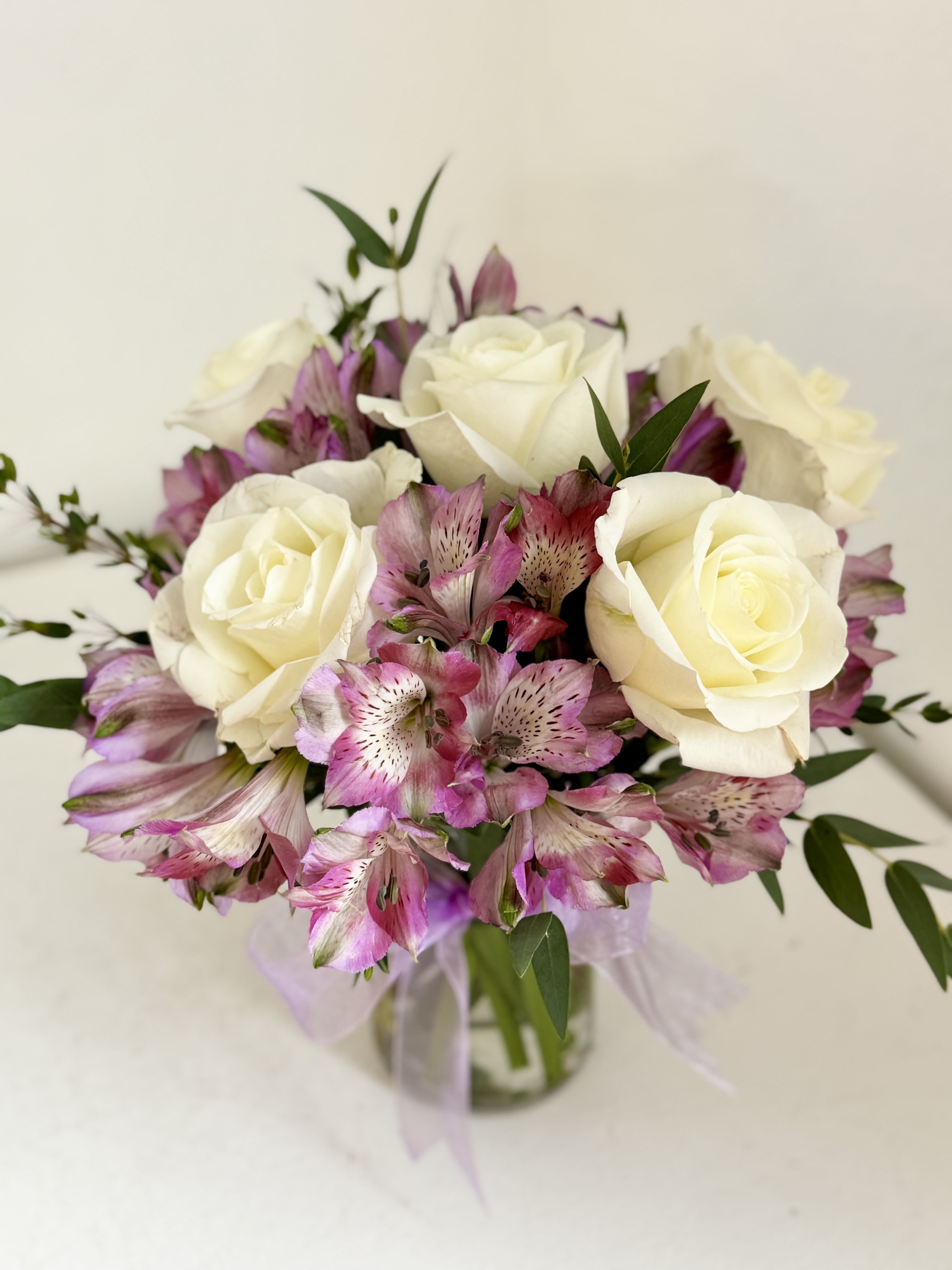 Bouquet of white roses and pink alstroemeria in a glass vase