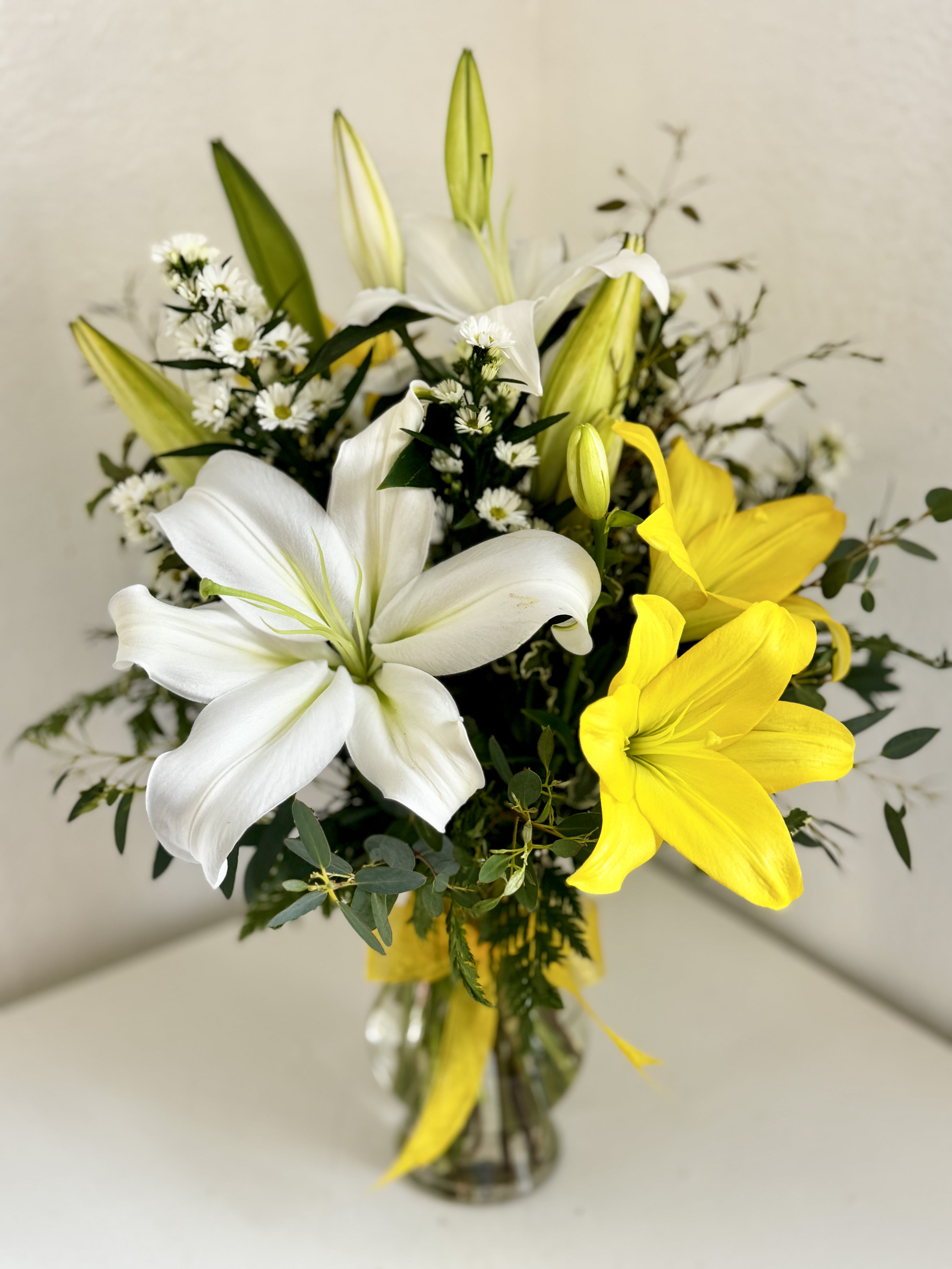 Lily Grace - **Lily color may vary depending on season** Enjoy sending a bouquet of ONLY lilies, filler, and greenery; perfect for someone who loves the popular elegant and fragrant flower, this bouquet will surely stand out! Consider upgrading to add even more lilies and make the arrangement even more grand!