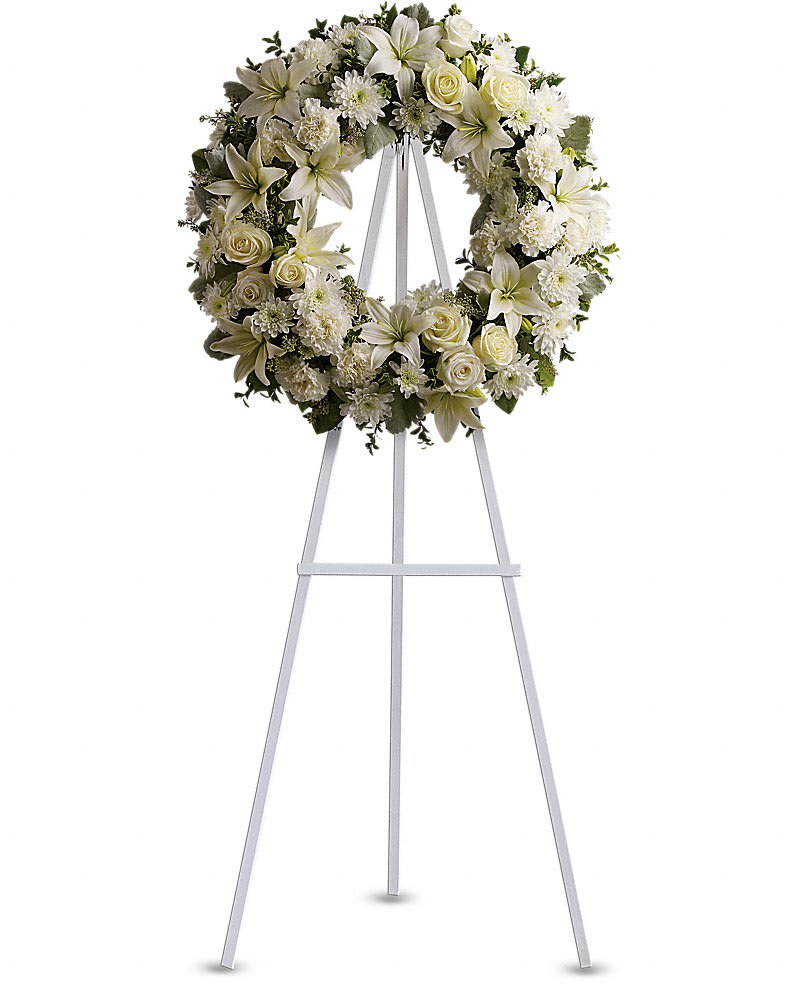 Serenity Wreath - A ring of fragrant bright white blossoms will create a serene display at any funeral or wake. This classic wreath is delivered on an easel and is a thoughtful expression of sympathy and admiration. A standing wreath created from fresh white flowers such as roses Asiatic lilies carnations and cushion spray chrysanthemums - accented with greenery - is delivered on an easel.Approximately 22" W x 22" H