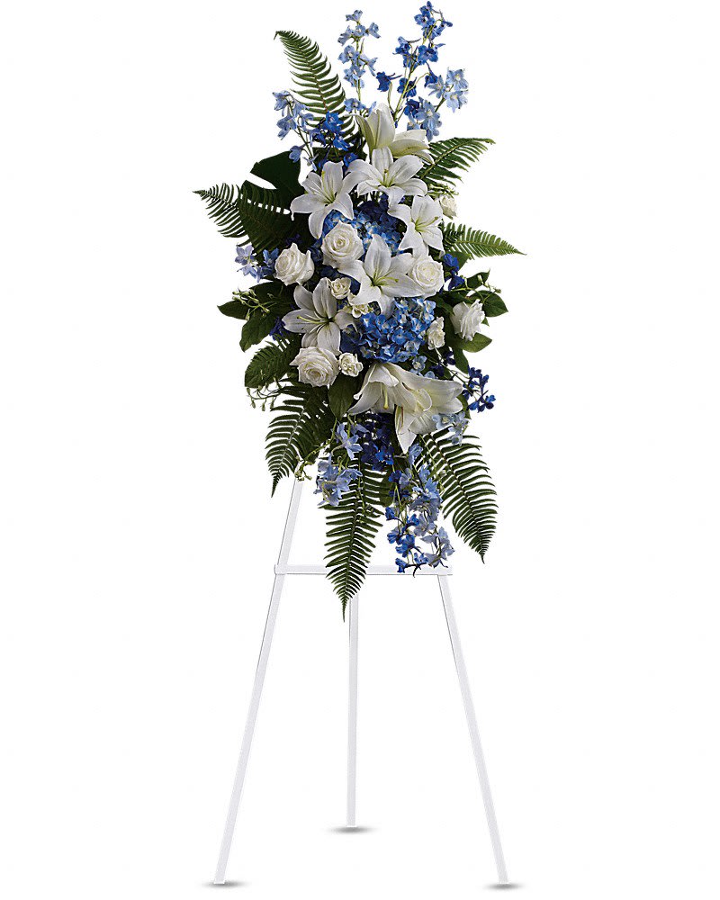 White lilies and blue flowers arranged on a standing easel