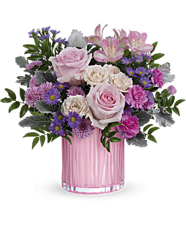 Pink and white roses with purple flowers in a pink glass vase