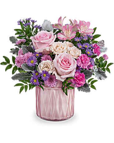 Pink and purple mixed flower arrangement in a pink glass vase