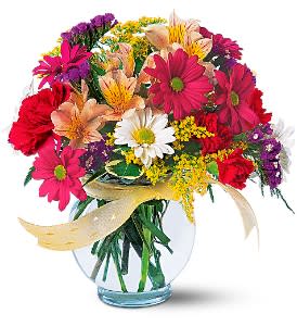 Colorful mixed bouquet in a clear glass vase with a ribbon