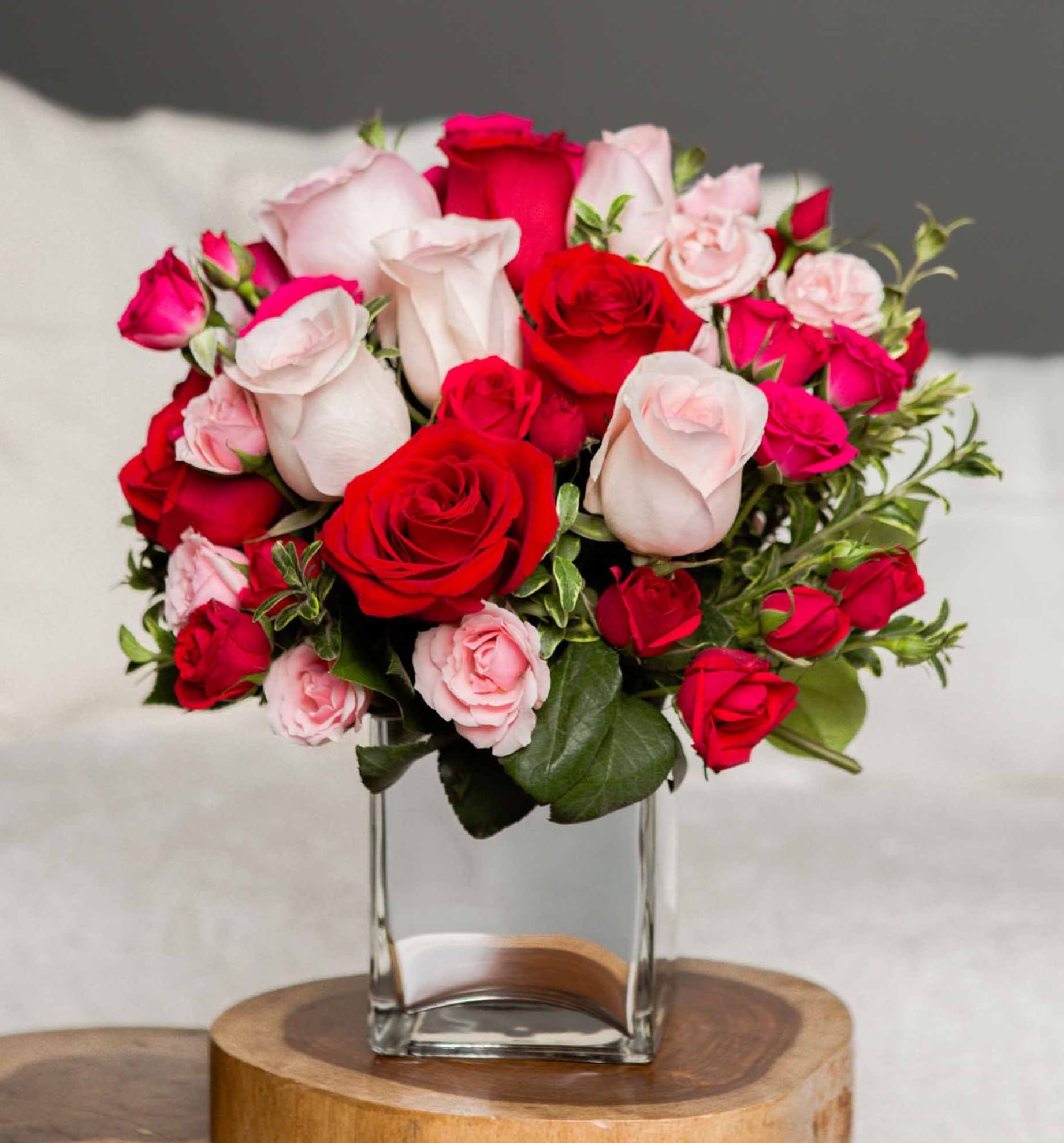 Bouquet of red and pale pink roses in a clear glass vase