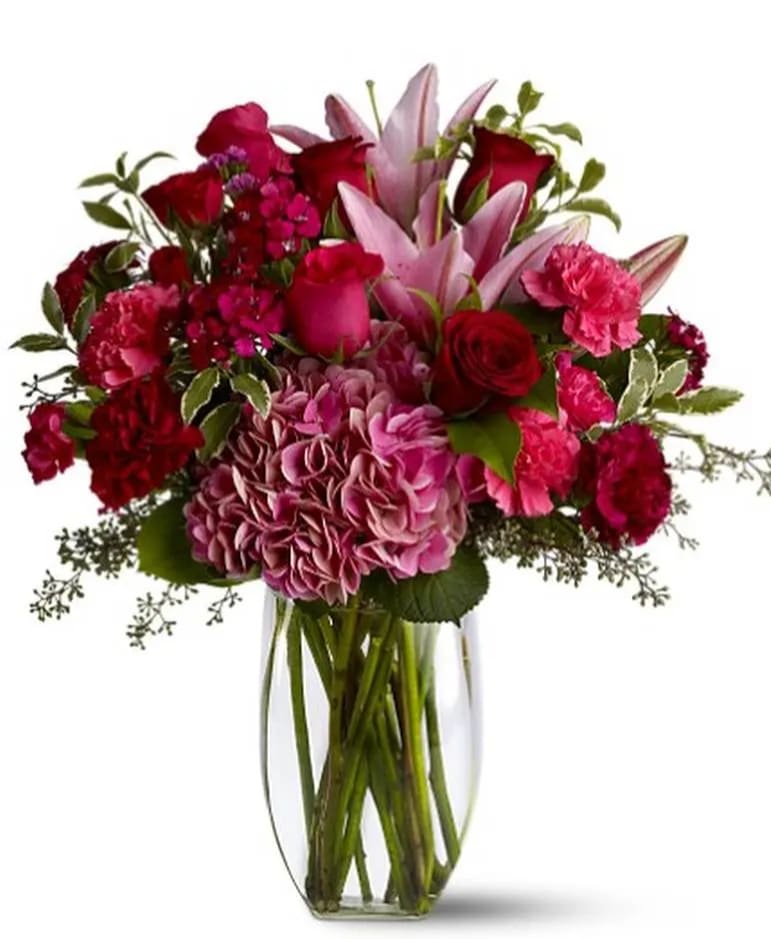 Bouquet of pink and red flowers in a clear glass vase