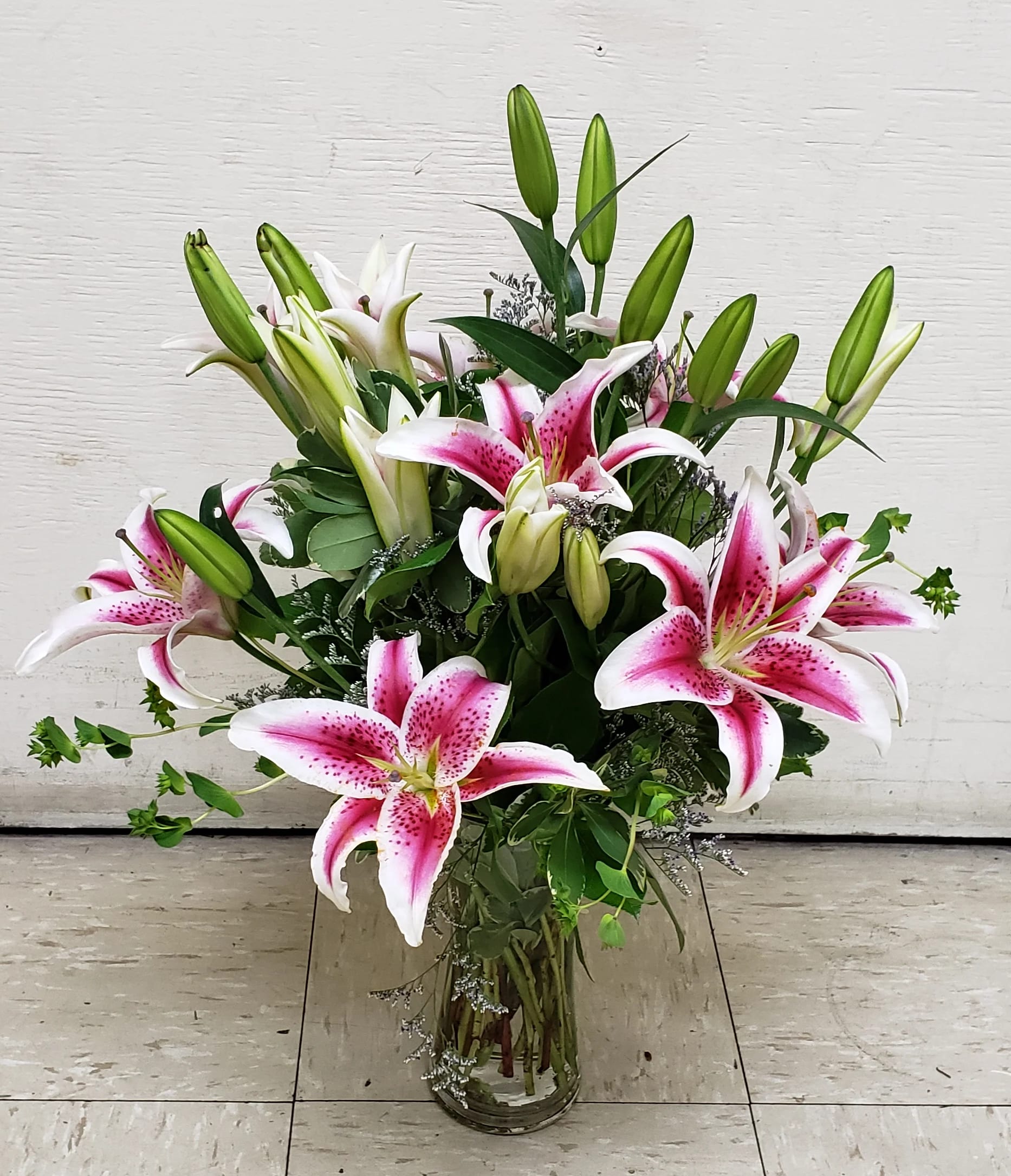 Pink stargazer lilies arranged in a clear glass vase