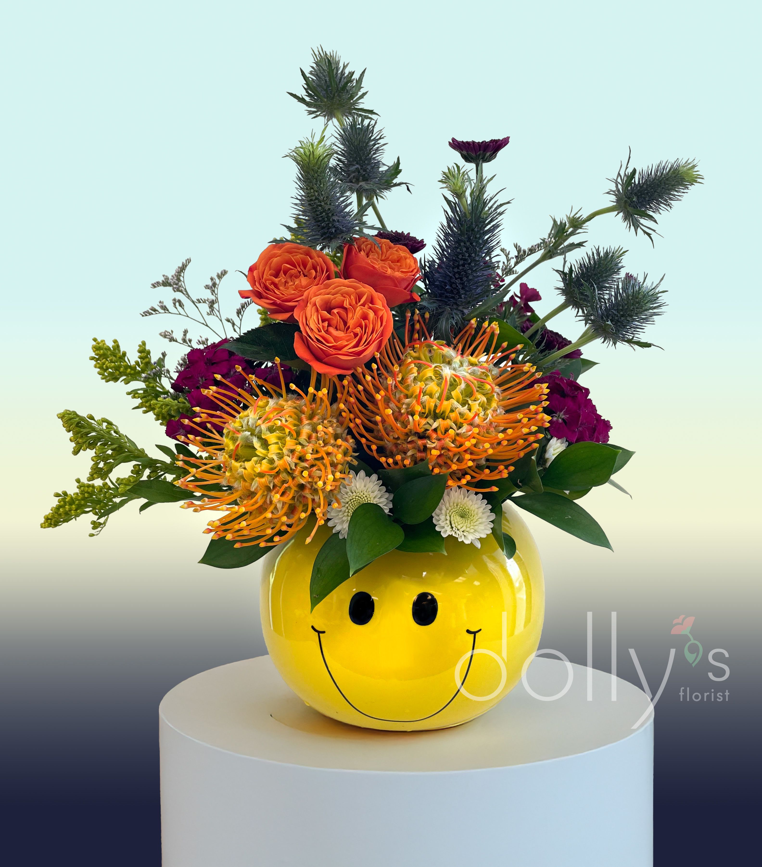 Bright mixed bouquet in a yellow smiley-face vase