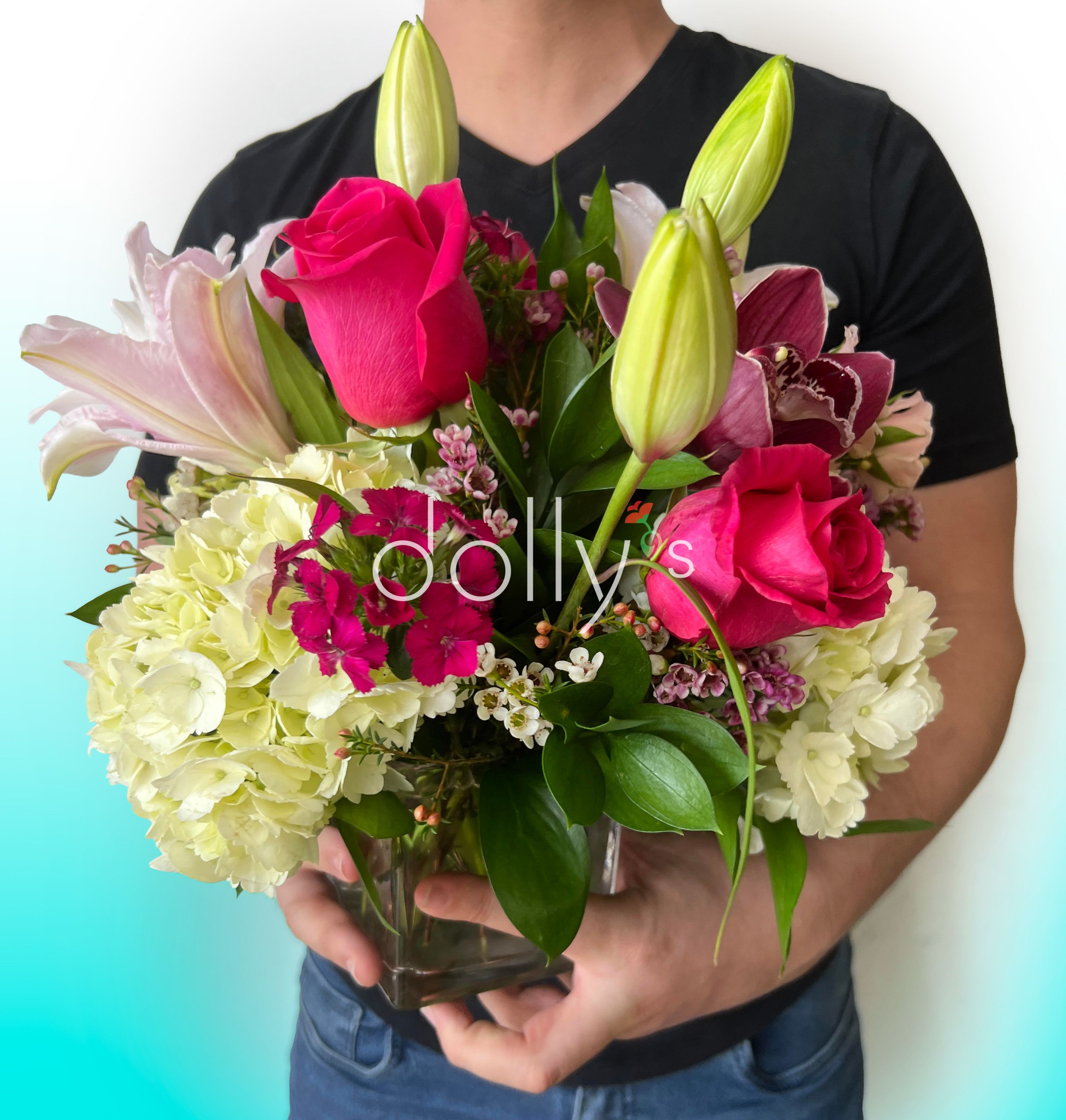 Bouquet of pink roses, lilies, and hydrangeas in a glass vase