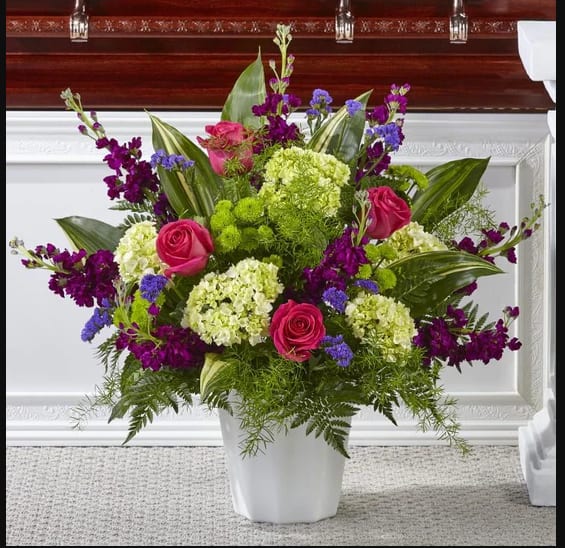 Pink roses and purple flowers in a white vase