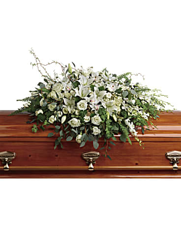 White floral spray on a wooden casket
