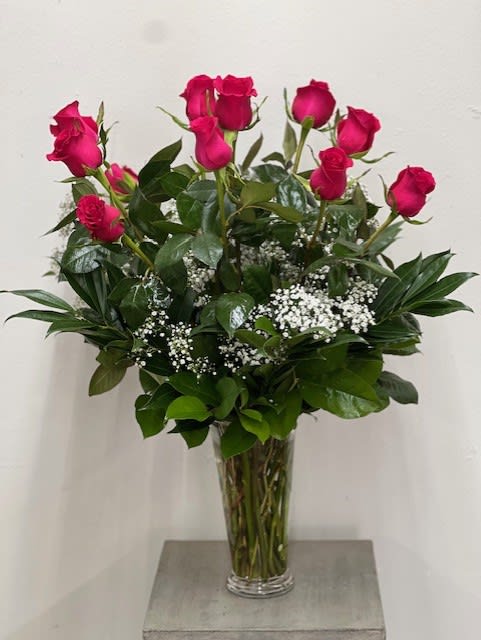 Tall vase arrangement of hot pink roses with baby's breath