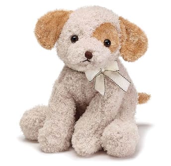 Small plush puppy dog with cream fur, brown ears, and a bow around its neck