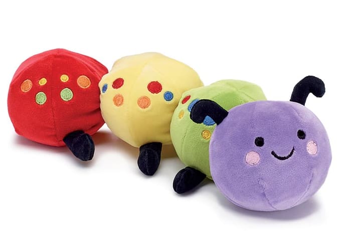 Four colorful plush caterpillar toys with smiling faces