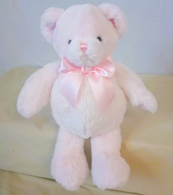 White teddy bear with a pink satin bow