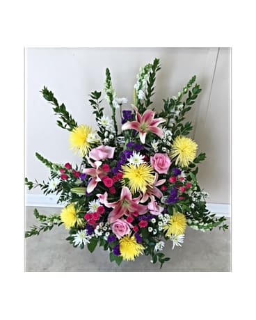 Large floral spray with pink lilies, roses, and yellow blooms
