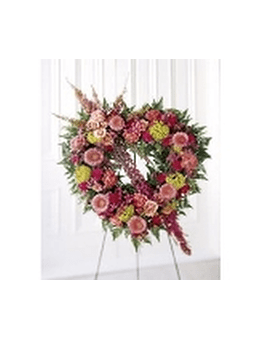 Heart-shaped floral wreath on an easel with pink and yellow blooms