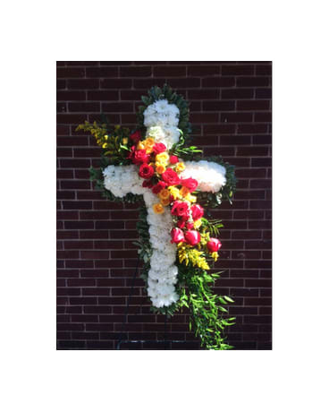 Cross-shaped floral tribute with white flowers and red, yellow, and pink roses