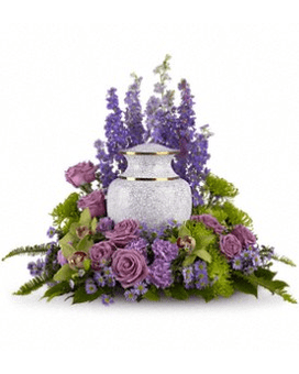 Lavender roses and purple flowers arranged around a white urn