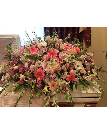 Large pastel floral casket spray with pink and white blooms
