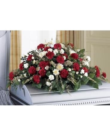 Red and white floral casket spray on a white casket