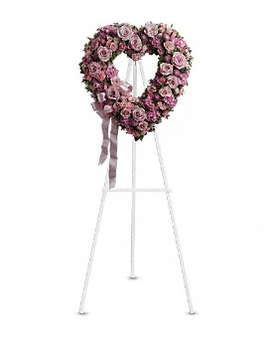 Heart-shaped pink rose funeral wreath on a white stand