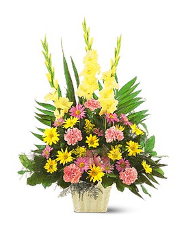 Tall mixed flower arrangement in a gold container with yellow, pink, and coral blooms