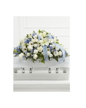 White and blue floral casket spray with a pale blue ribbon