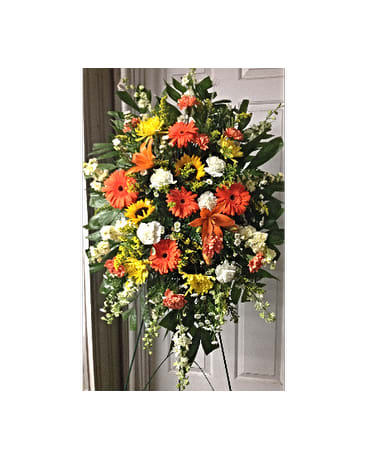 Standing spray of orange, yellow, and white flowers on an easel