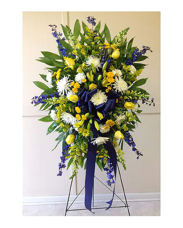 Tall standing floral spray with yellow, white, and blue flowers
