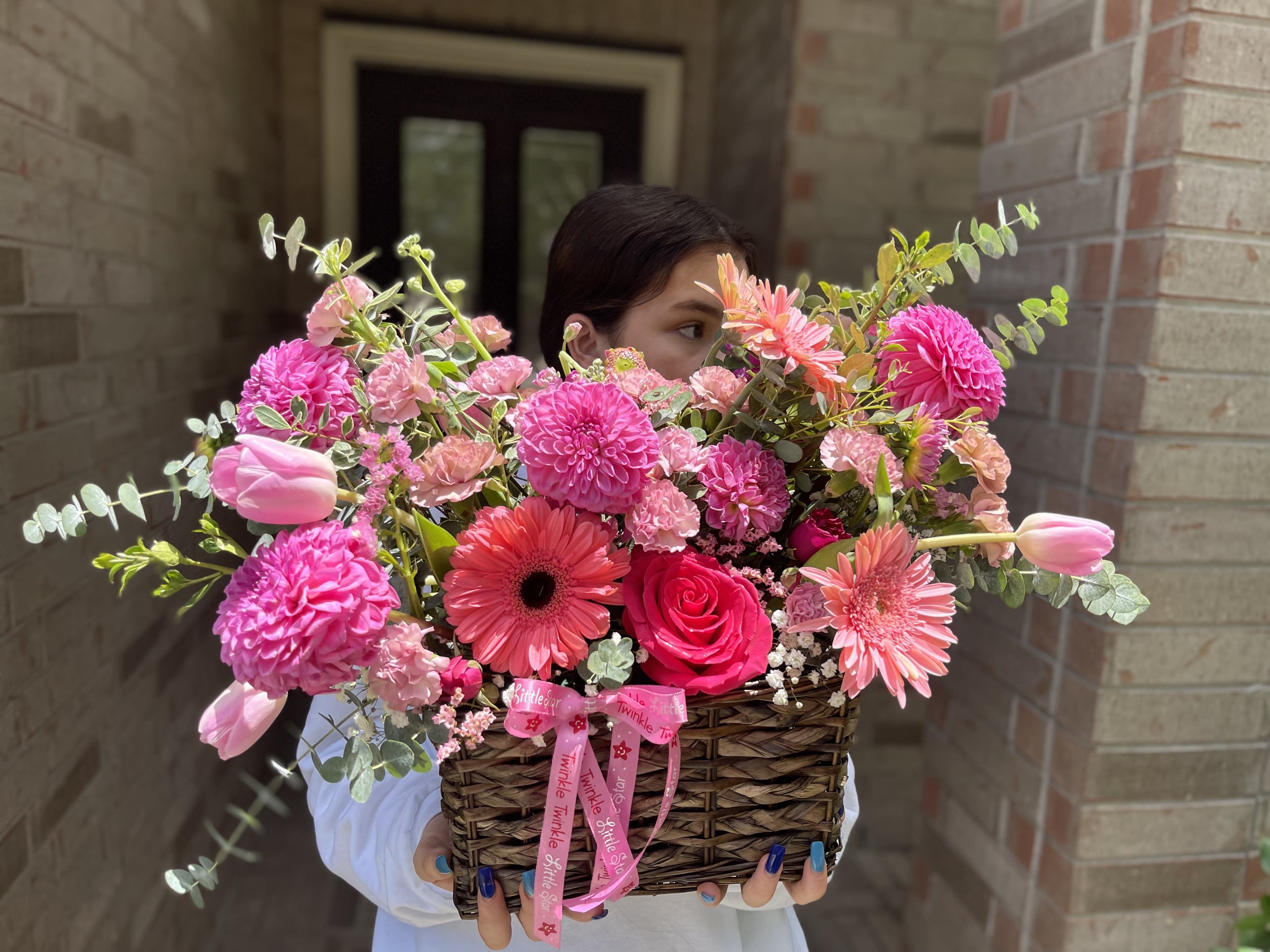 Basket of pink flowers with tulips, roses, and daisies