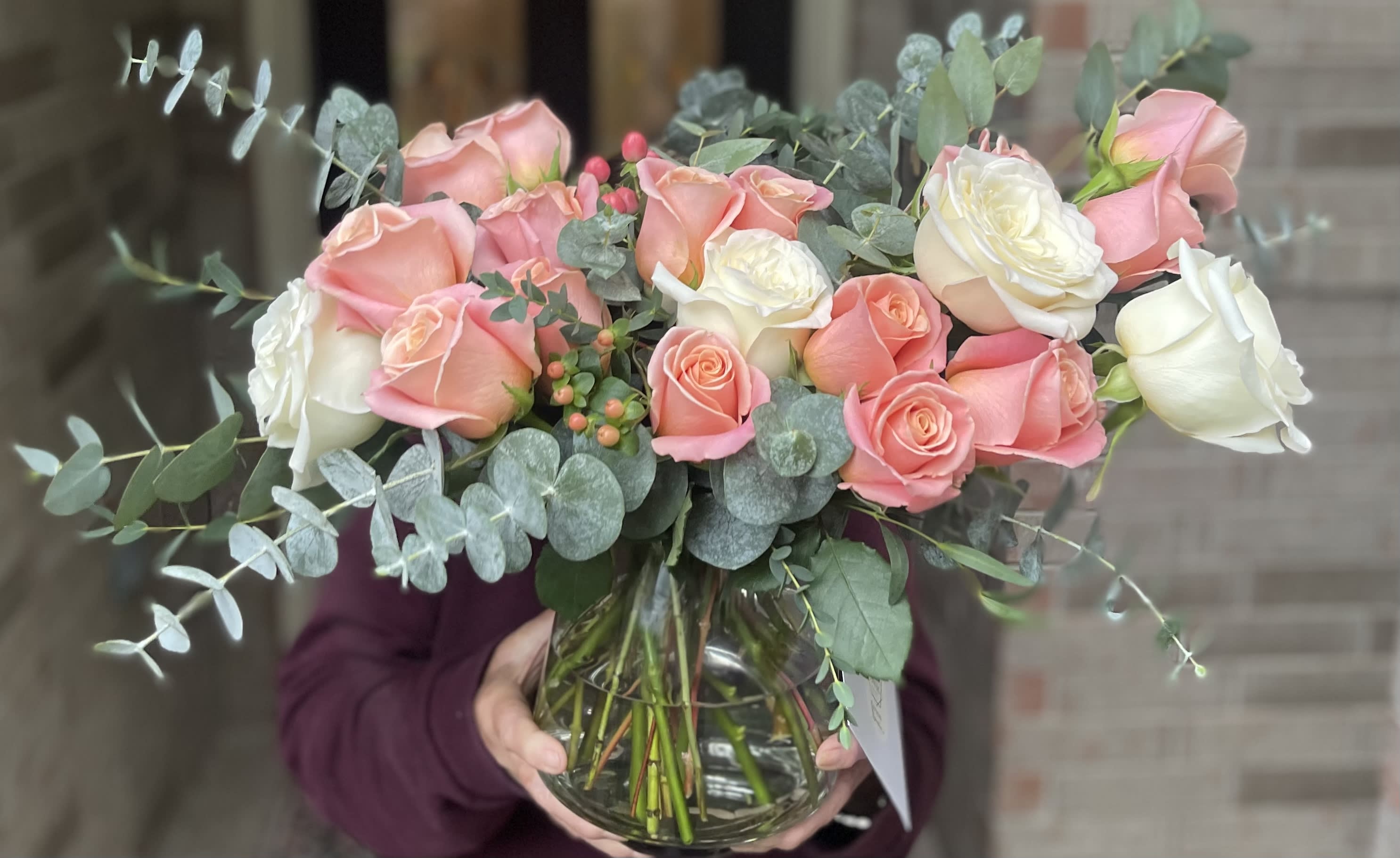 Bouquet of pink and white roses in a clear glass vase