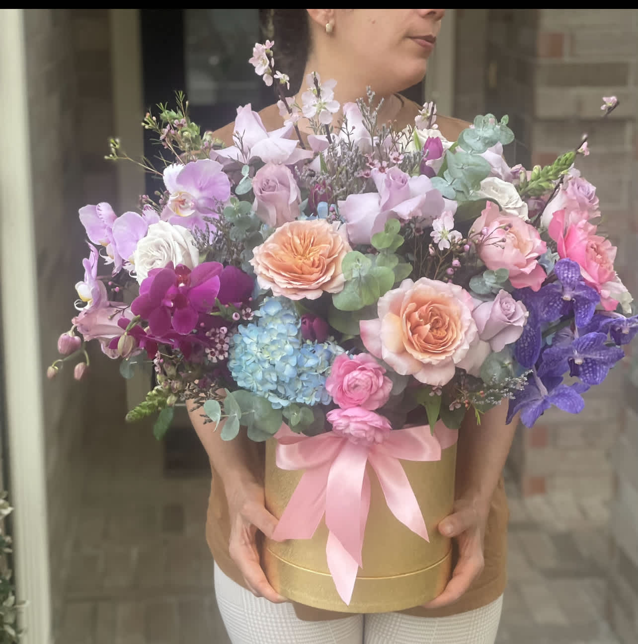 Large pastel bouquet in a gold box with a pink ribbon
