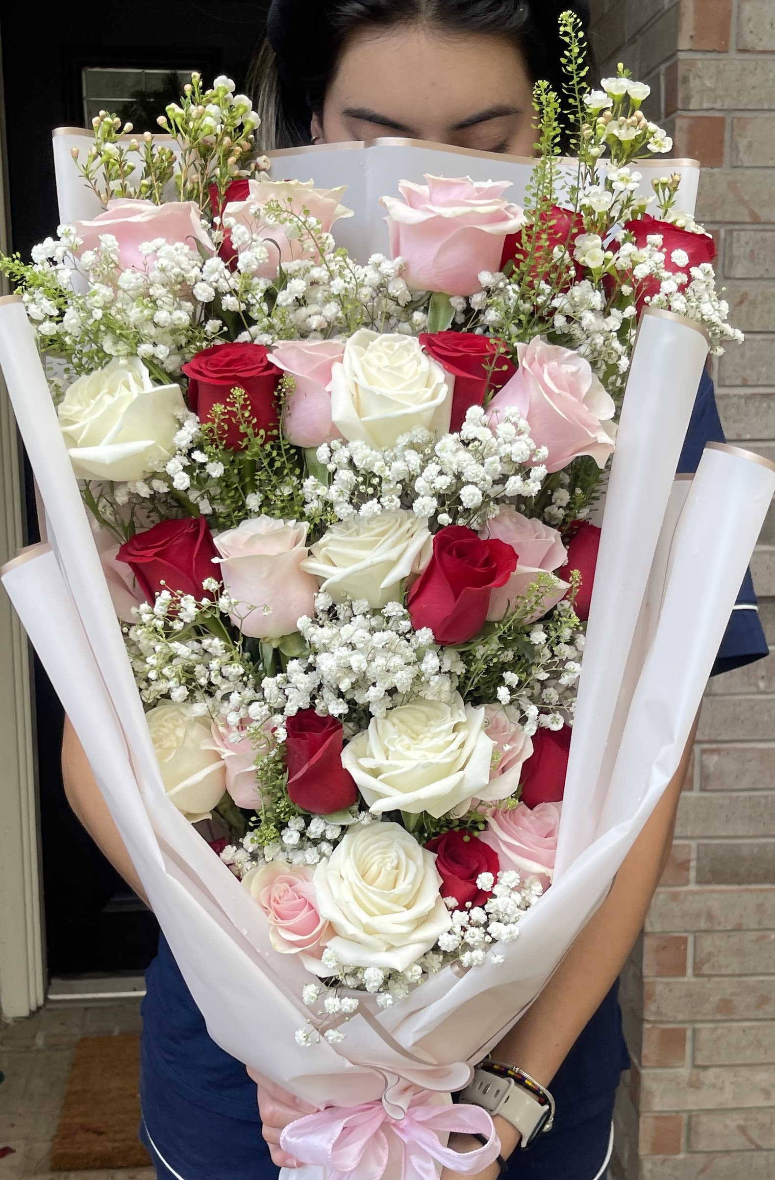 Large bouquet of pink, red, and white roses with baby's breath