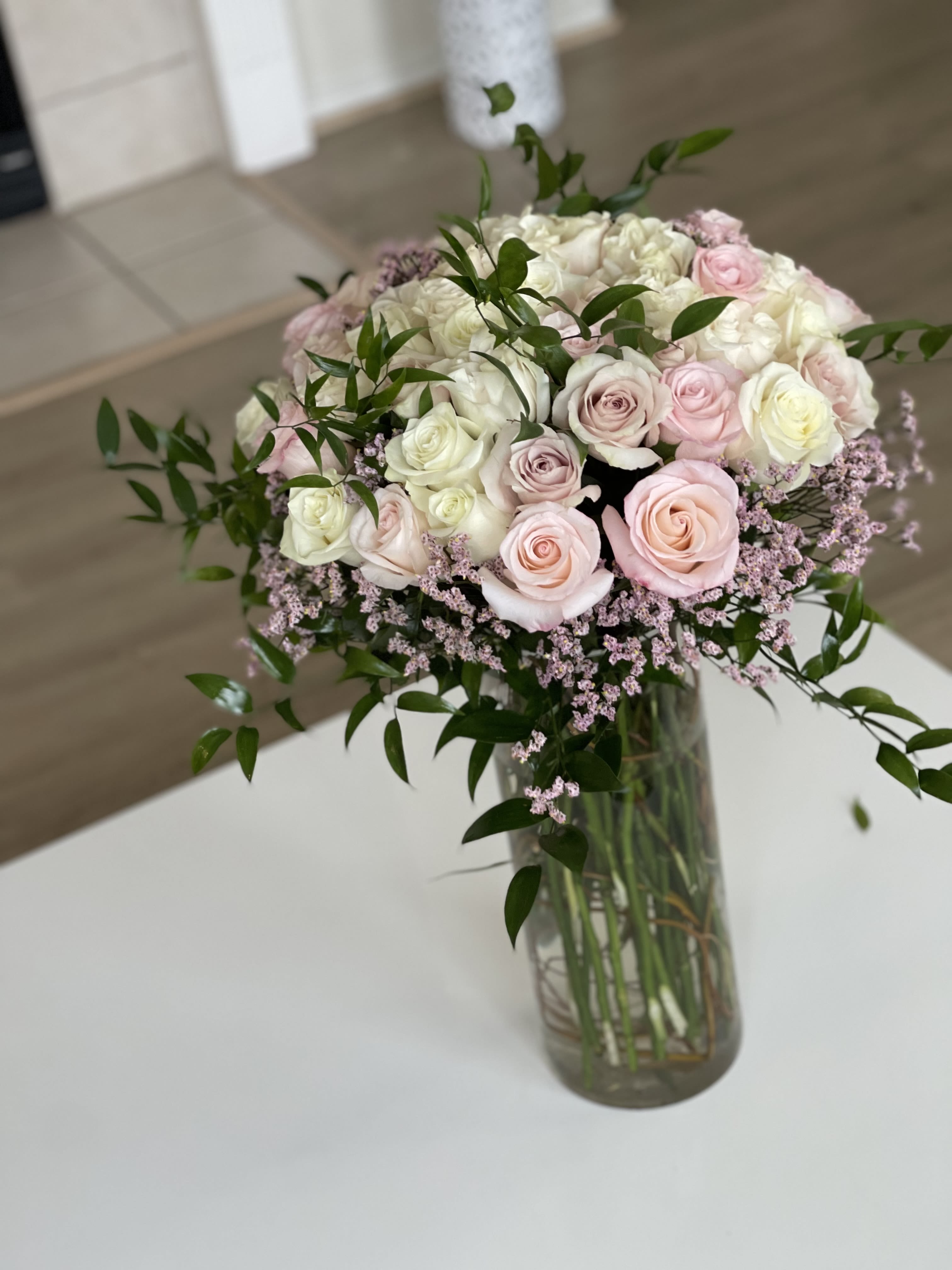 Bouquet of pale pink and white roses in a glass vase