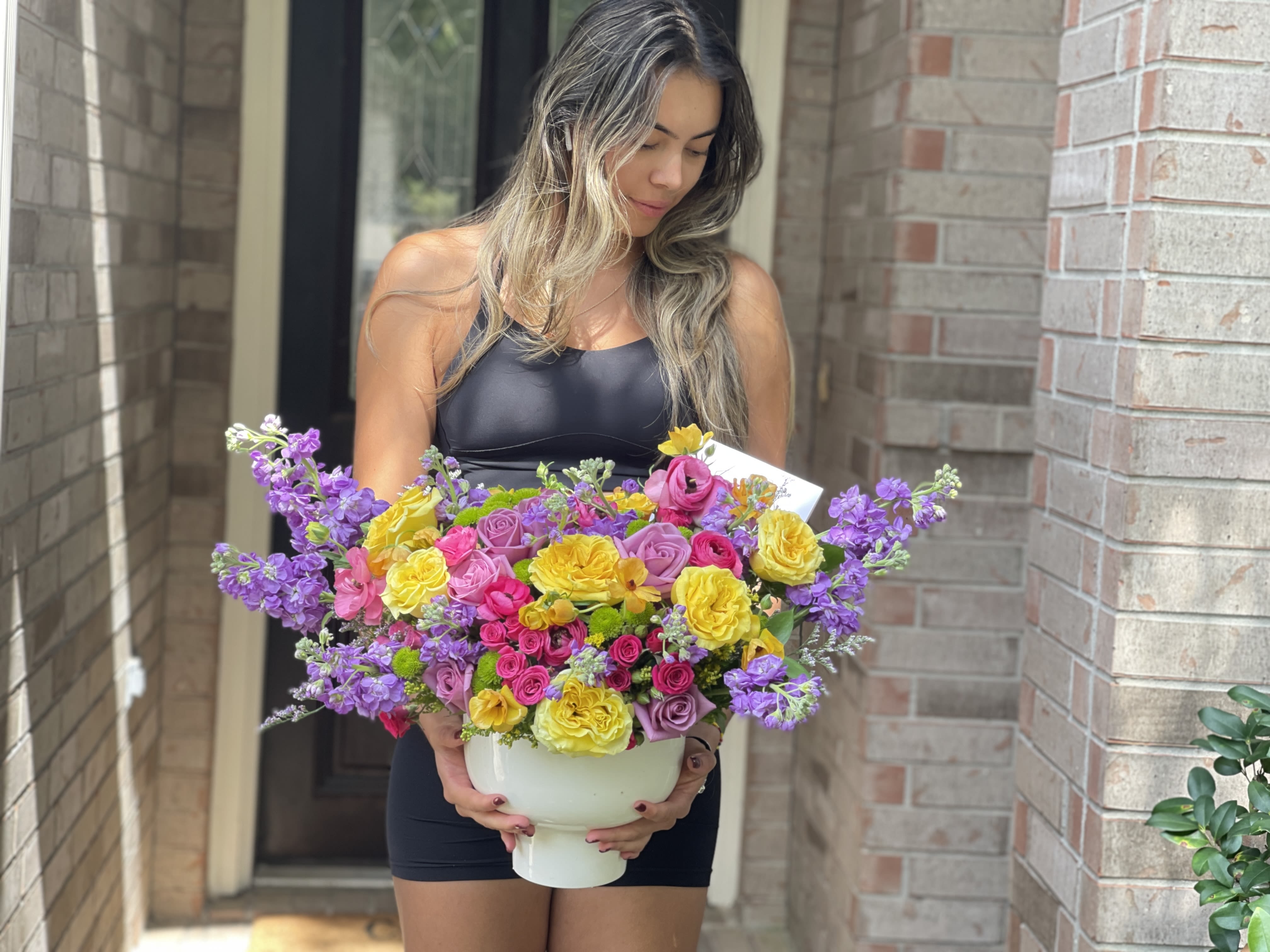 Woman holding a large bouquet in a white vase