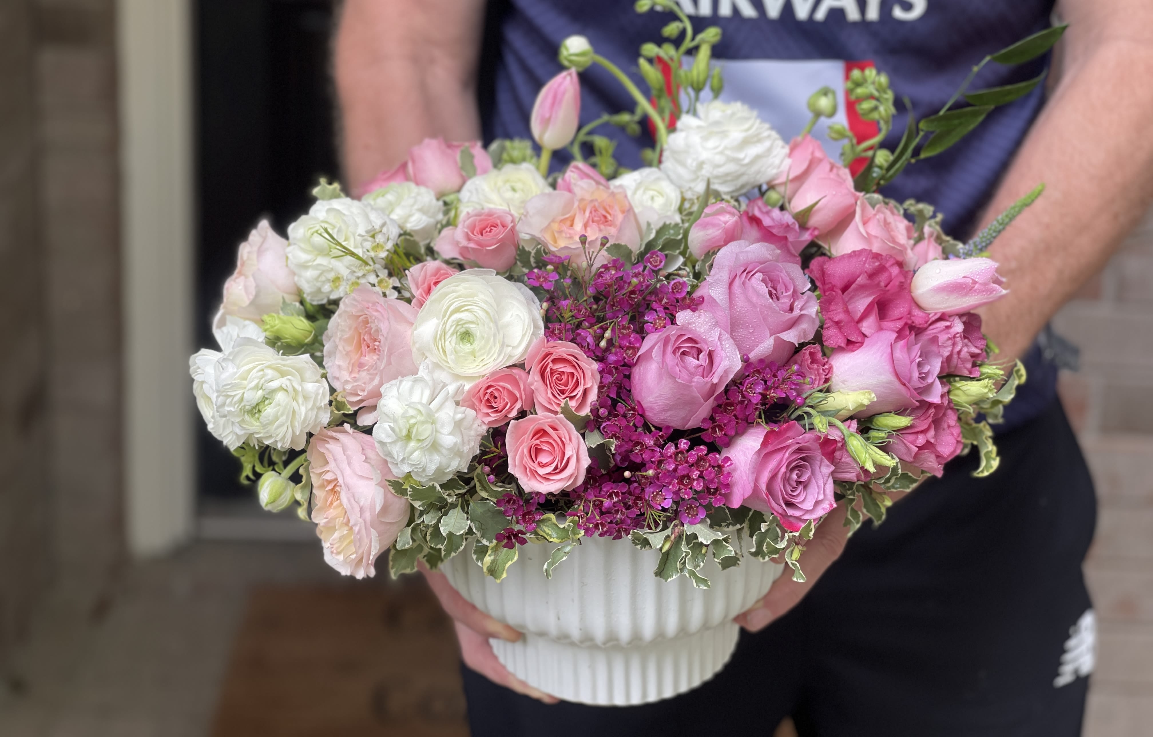 Pink and white rose bouquet in a white ribbed vase