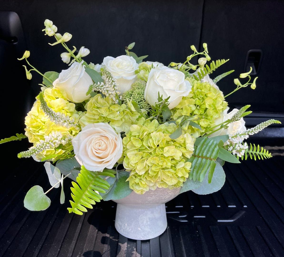 White roses and green hydrangeas in a white vase